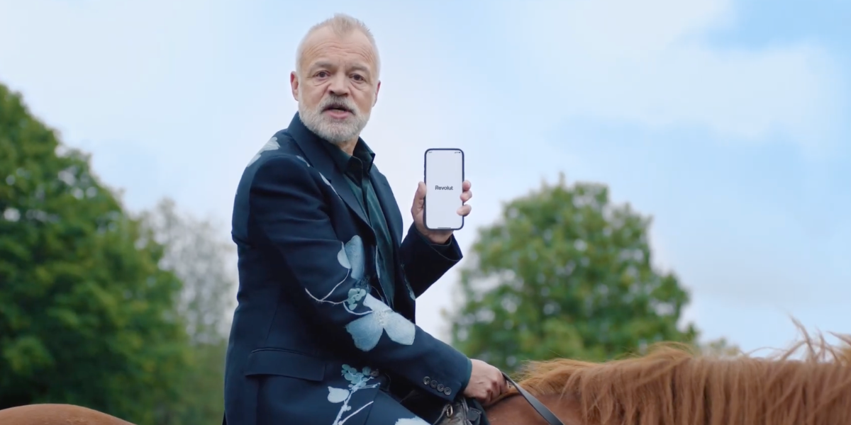 Man on horseback holds up his phone.