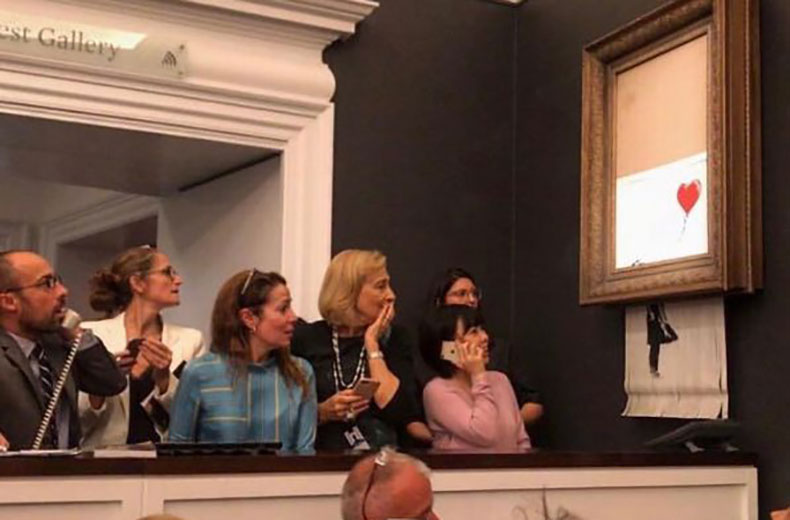 Banksy's Girl With Ballon shreds itself after being bought at a Sotheby's auction